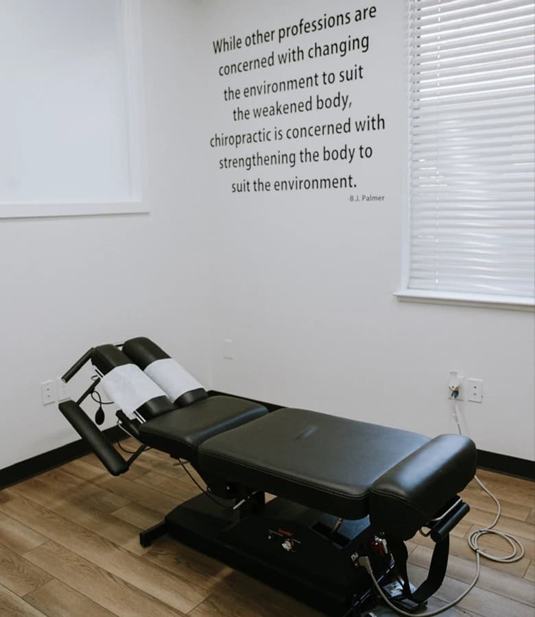 An adjustment room at Yuba Sutter Chiropractic with a B.J. Palmer quote painted on the wall